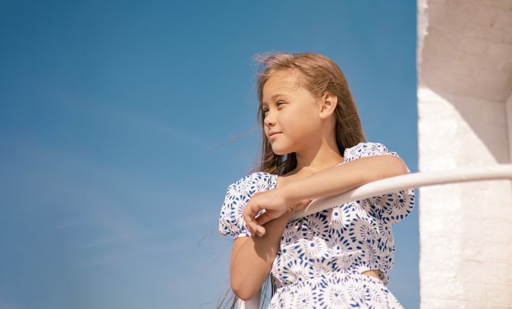 Girl in dress on the beach with long blond hair