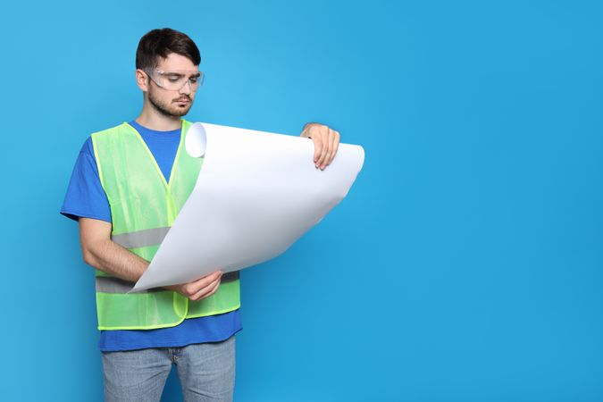 Young man civil engineer on blue background