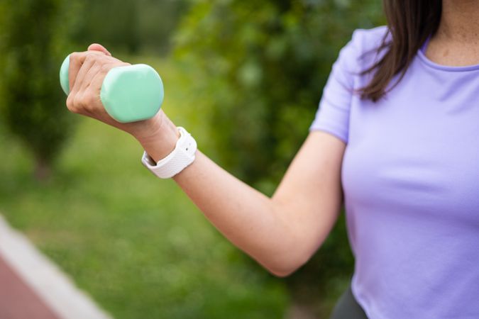 Woman doing weightlifting sport exercise outdoors