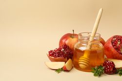 Beige room with honey pot, pomegranate and apple with copy space
