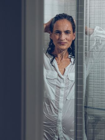 Woman in wet white shirt in shower cabin