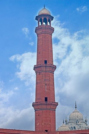 Brick minaret against blue sky in Lahore, Pakistan