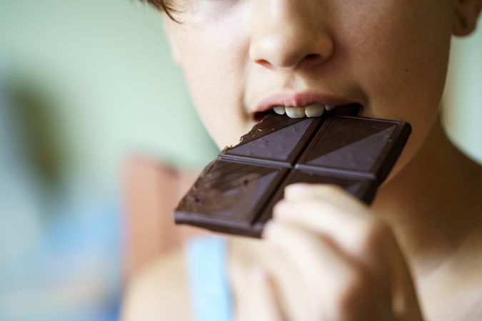 Girl biting into dark chocolate