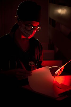 Female doctor reading notes on clipboard at staircase