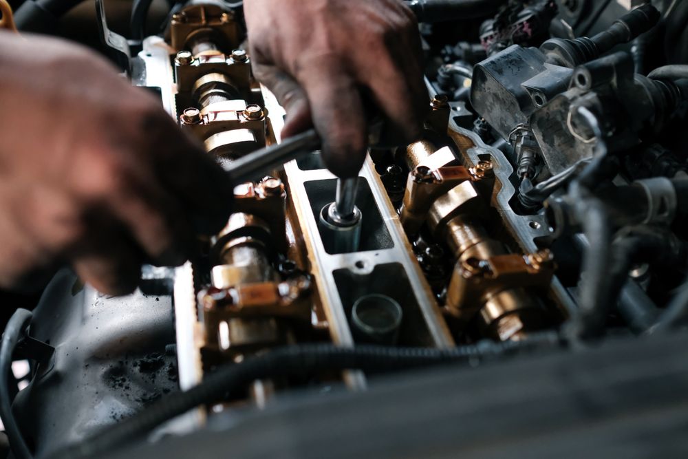 Close of mechanic’s hands in the hood of a vehicle
