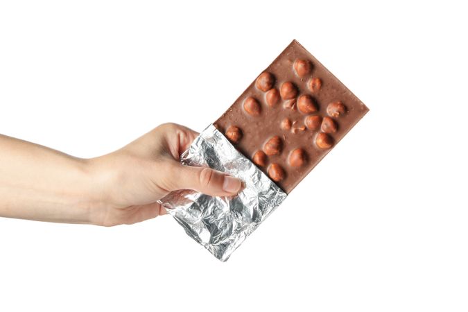 Female hand holding chocolate bar, isolated on blank background