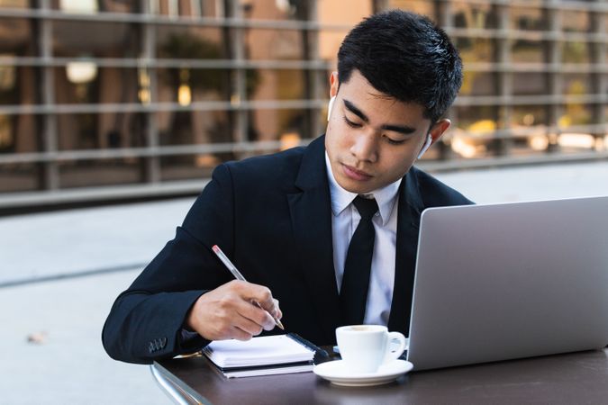 Serious male entrepreneur in suit working in cafe