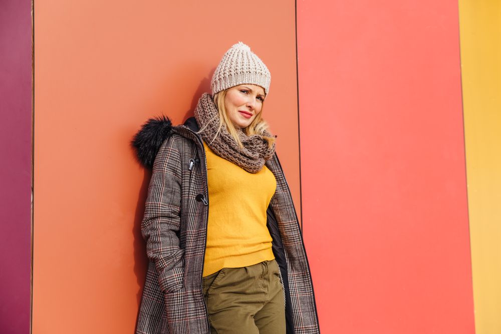 Blonde woman leaning on a colorful wall
