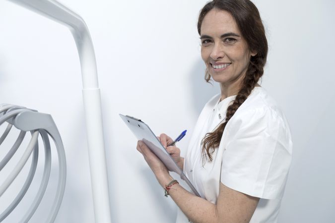 Portrait of confident happy smiling doctor holding clipboard with documents