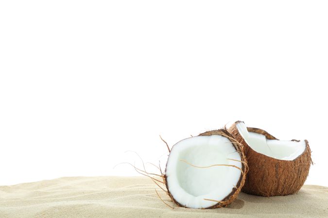 Coconuts on clear sea sand isolated on studio background. Summer vacation