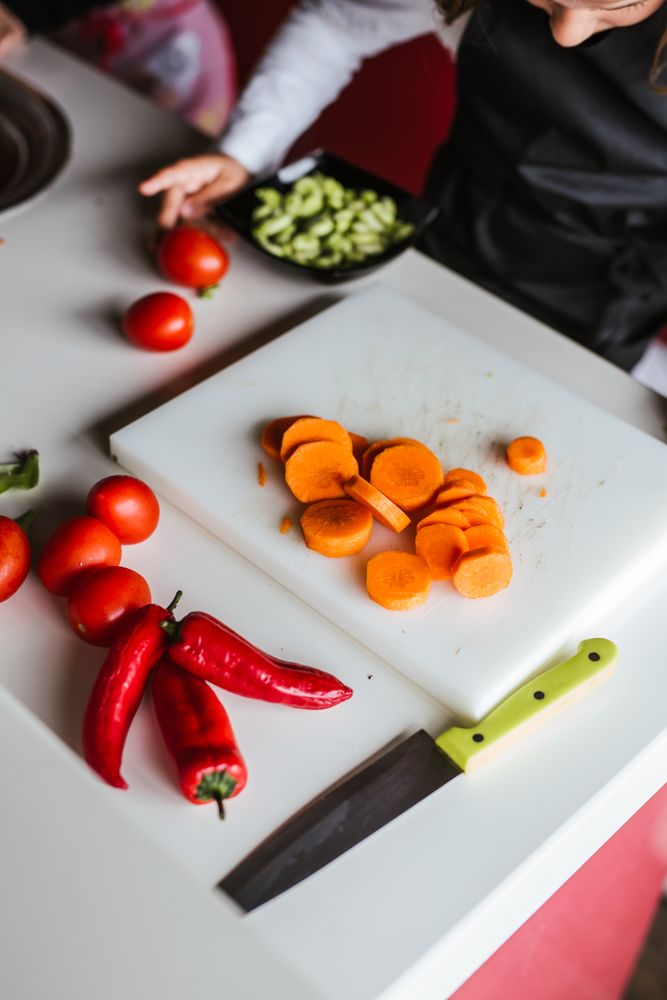 Anonymous kids preparing vegetables for salad