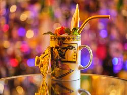 Exotic cocktail in porcelain cup served on table