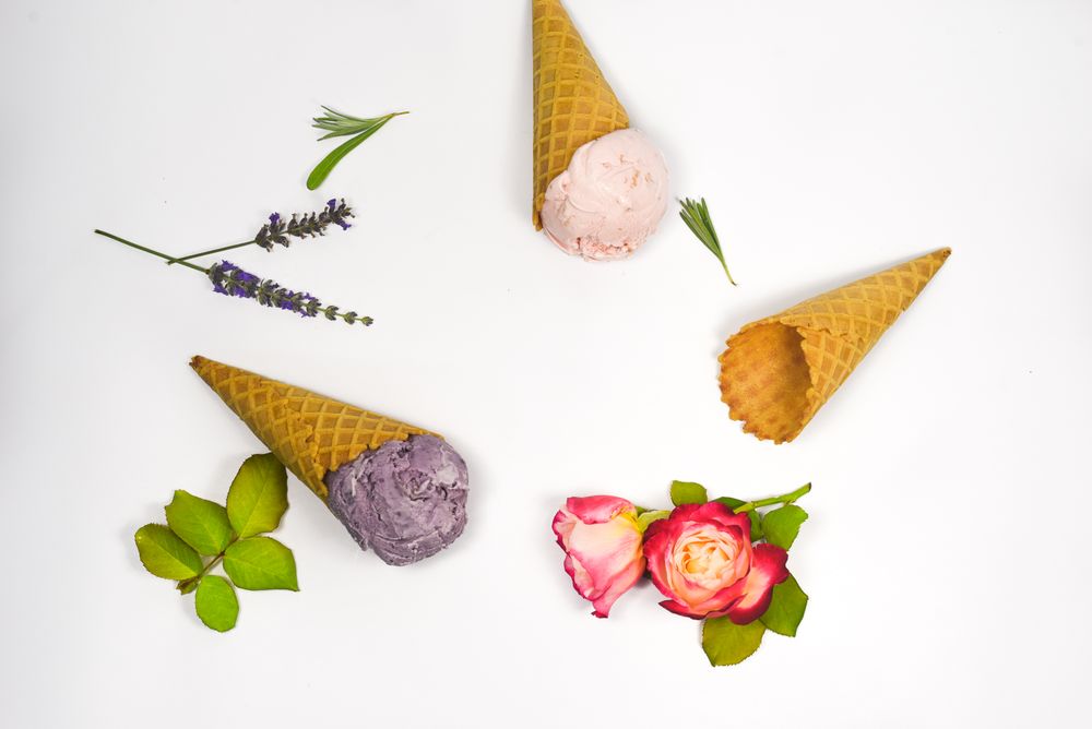 Top view of three waffle cones, two with ice cream scoops, one empty