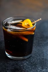 Side view of kumquat slice garnishing cocktail