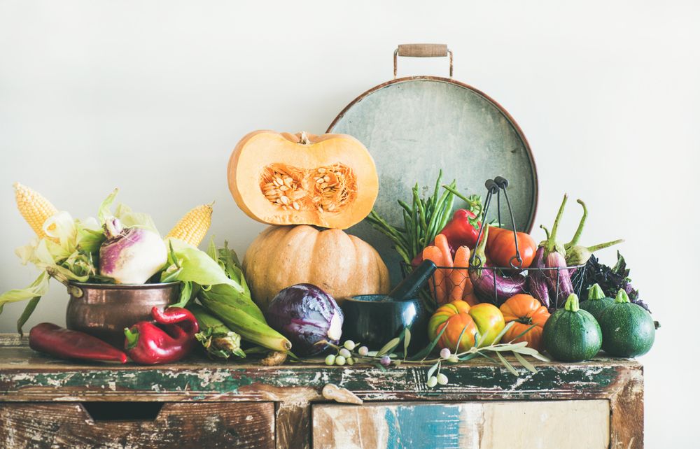 Fresh autumnal produce on kitchen counter, with halved squash and grey tray