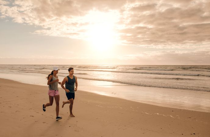 Couple running together on the sea shore