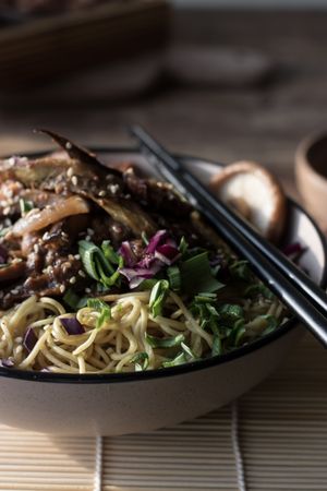 Miso noodles with egg plants and shiitake in bowl on table