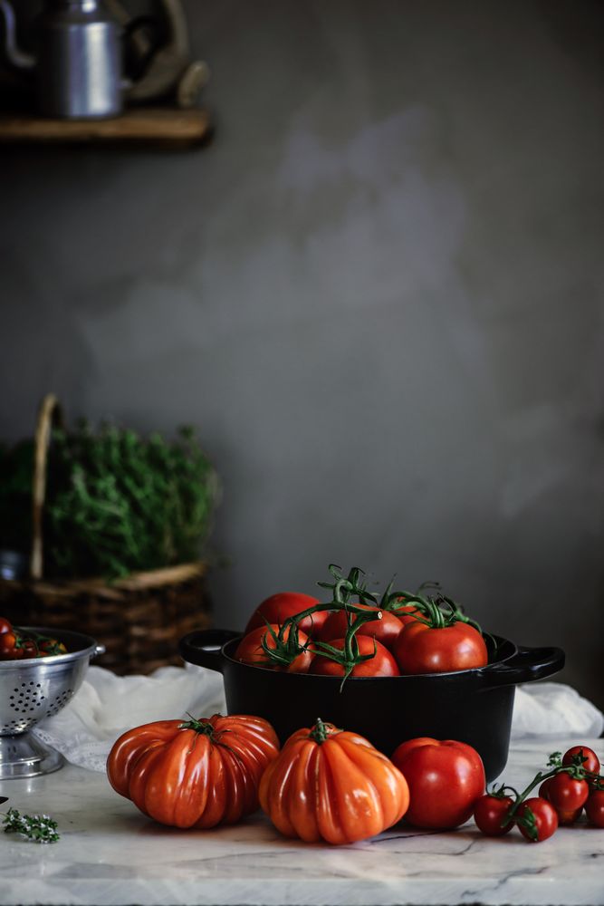 Ripe fresh tomatoes in pot on table
