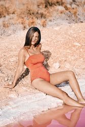 female resting on salty beach with pink water
