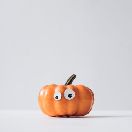 Pumpkin with eyes on light background