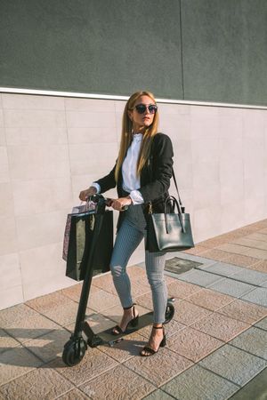 Woman with shopping bags on electric scooter