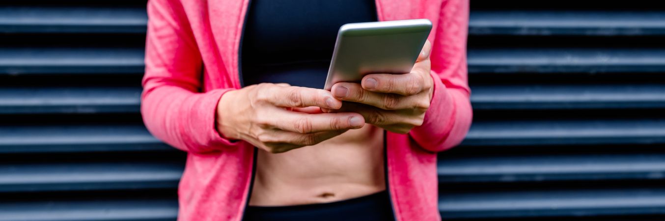 Unrecognizable female athlete with mobile phone