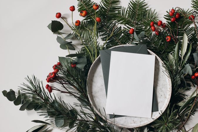 Festive Christmas branches with ceramic plate and blank paper card