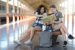 Young female travelers looking at a map on the train platform