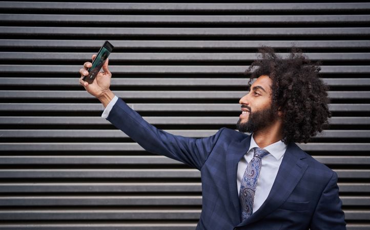 Joyful man taking selfie and smiling