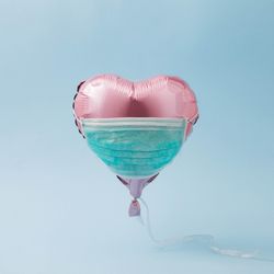 Pink foil heart balloon with protective mask
