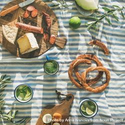 Summer picnic spread with pretzels, mojitos, meat and cheese board 5o37m5