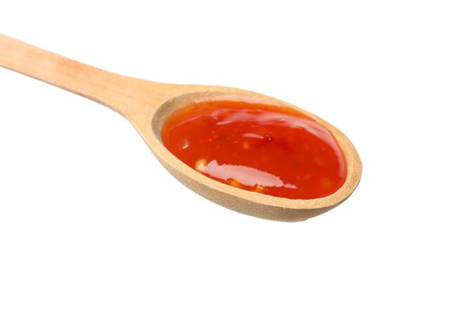 Spoon with hot sauce isolated on blank background