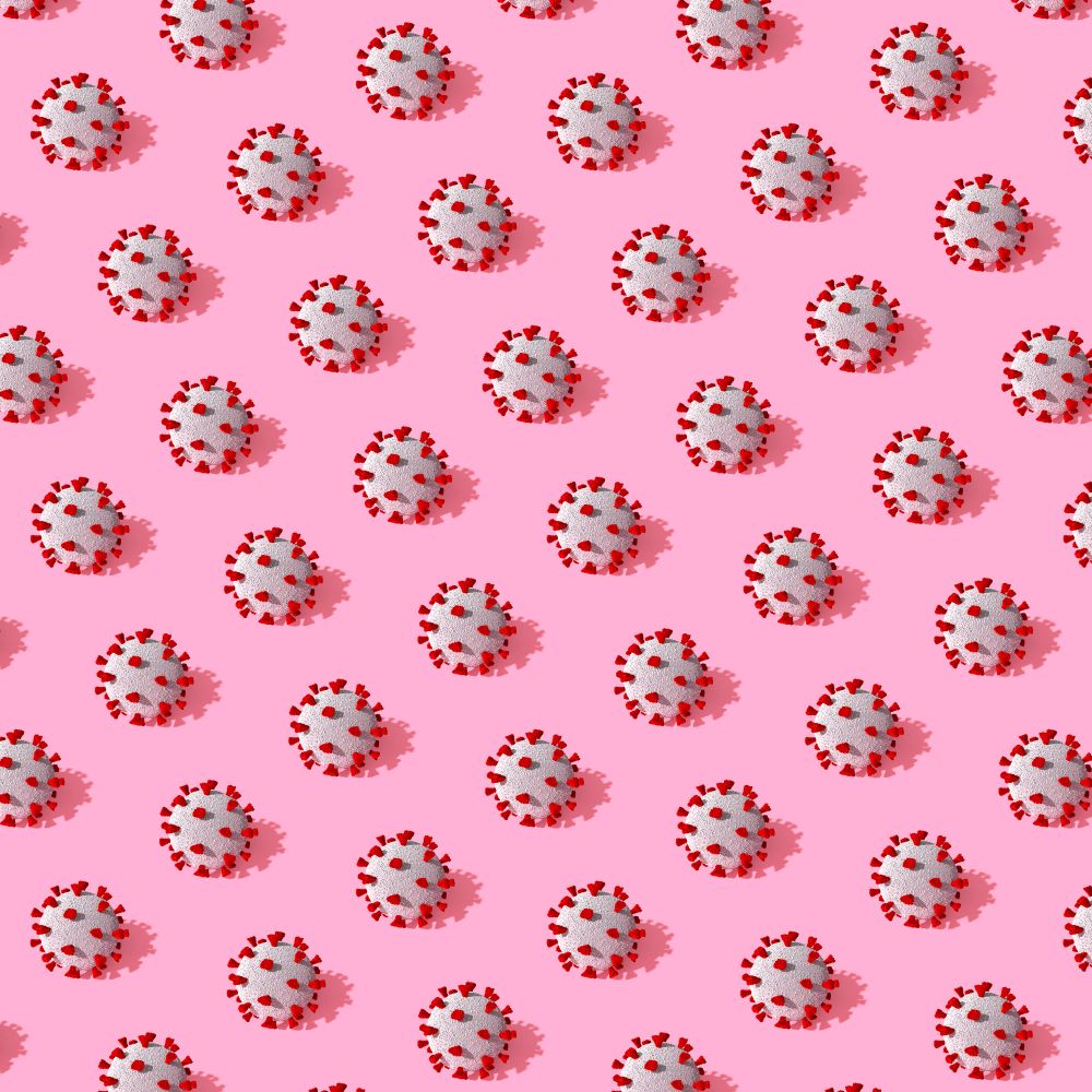 COVID-19 virus pattern in rows on pink background
