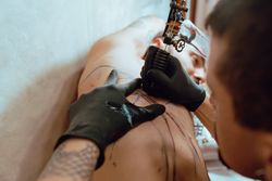 Stylish man drawing tattoo
