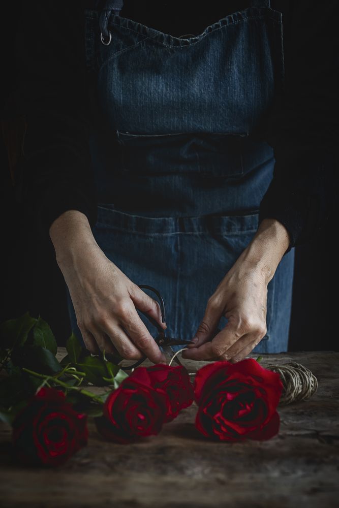 Unrecognizable woman making a bouquet of red roses