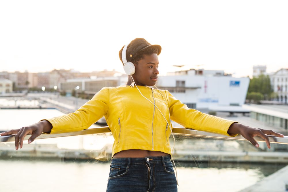 Peaceful female enjoying music and relaxing on balcony