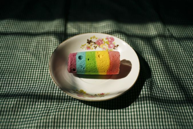 Multicolored cake on plate resting on table