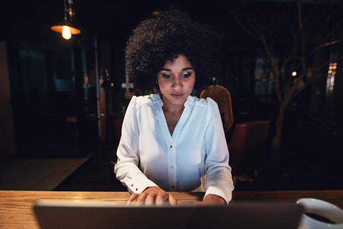 Young businesswoman working late on laptop in office