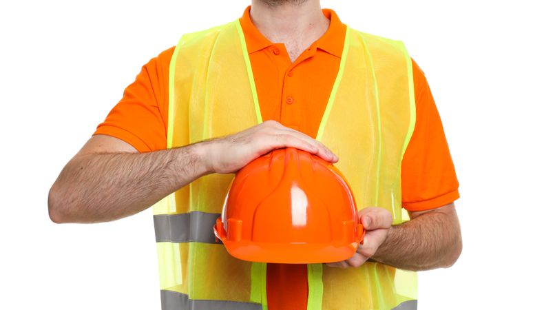 Young man civil engineer with safety hat isolated on light background