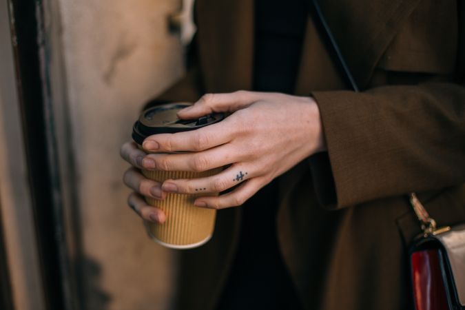 Close up of female hands holding to go coffee