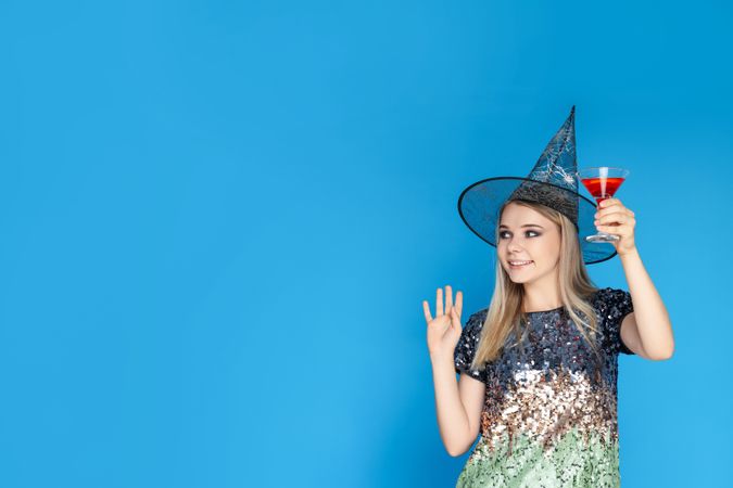 Concept of Halloween, young woman on blue background