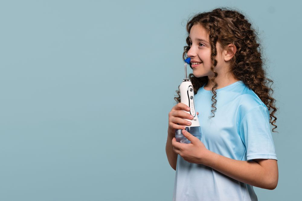 Girl smiling while using an oral irrigator