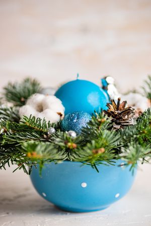 Close up of Christmas wreath with blue baubles and pines on table
