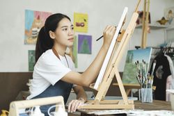 Crafting Inspiration: Female Artist Sketching and Painting in Workshop