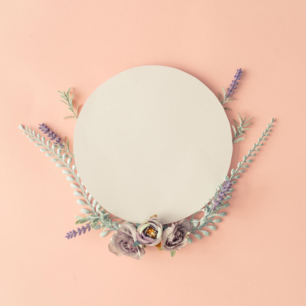 Creative layout made with spring flowers and leaves on pastel pink background