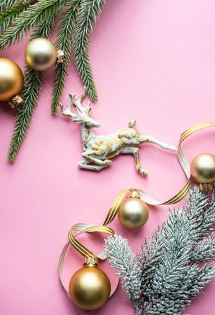 Christmas pine and golden decorations on pink background