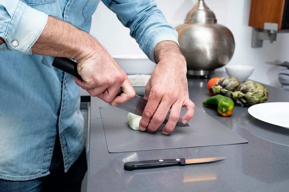 Man prepping onion on board