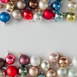 Colorful bauble decorations bordering light background