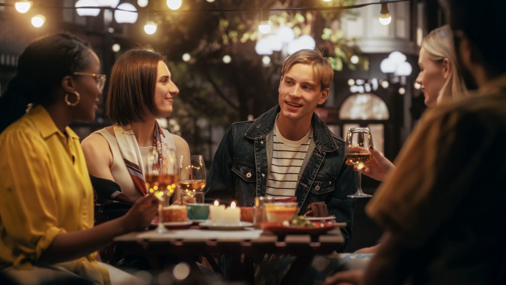 Diverse Group of Friends Enjoying Nightlife in a Street Cafe.