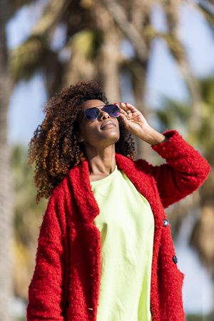 Confident female smiling in the sun on street with palm trees